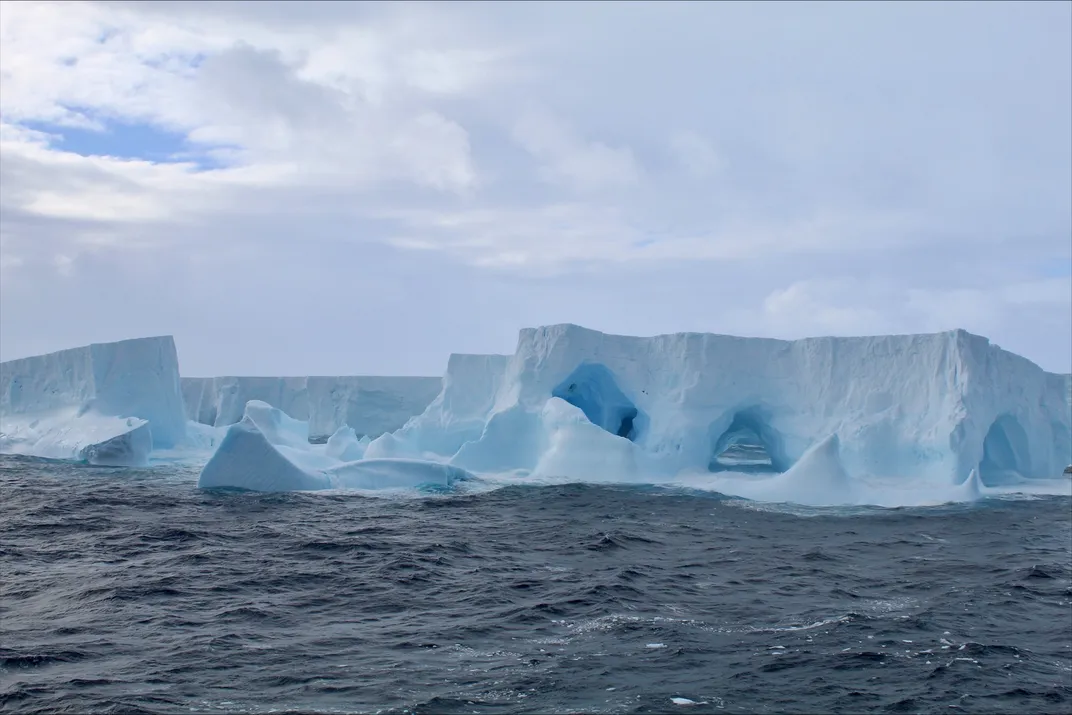 a large iceberg with some cavernous formations above the water