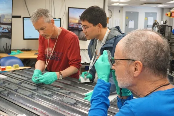 Johan Lissenberg (left) and colleagues Haiyang Liu and Mark Reagan analyzing the cores