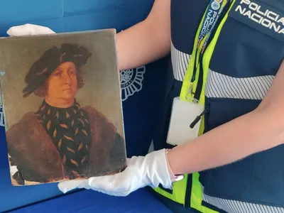 A police officer poses with the fake Leonardo da Vinci portrait.