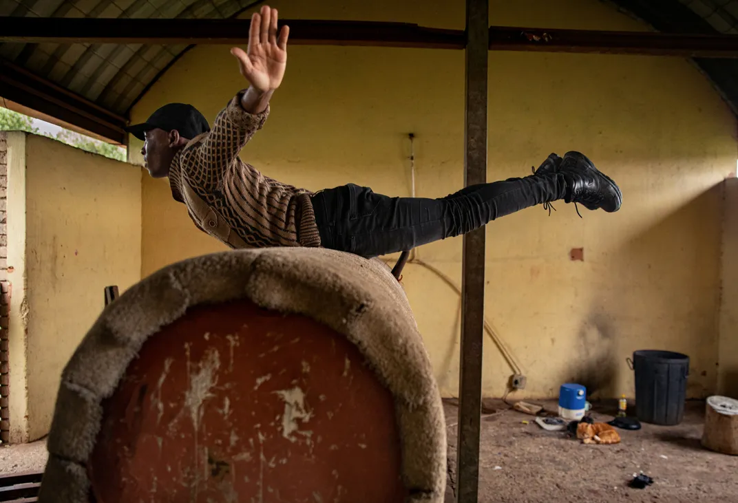 Tshepo Masemola, a trainer at the center, demonstrates a vaulting exercise atop an old oil drum that’s been converted into a makeshift practice horse.