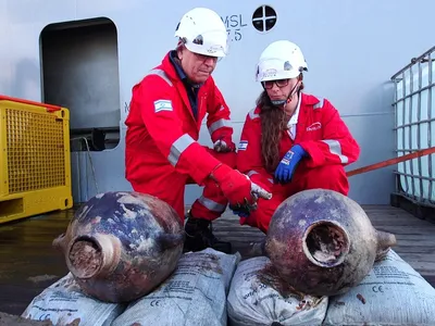 Jacob Sharvit and Karnit Bahartan examine the two amphorae recovered from the wreck.