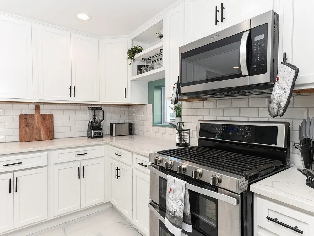 A microwave in a kitchen with white cabinets